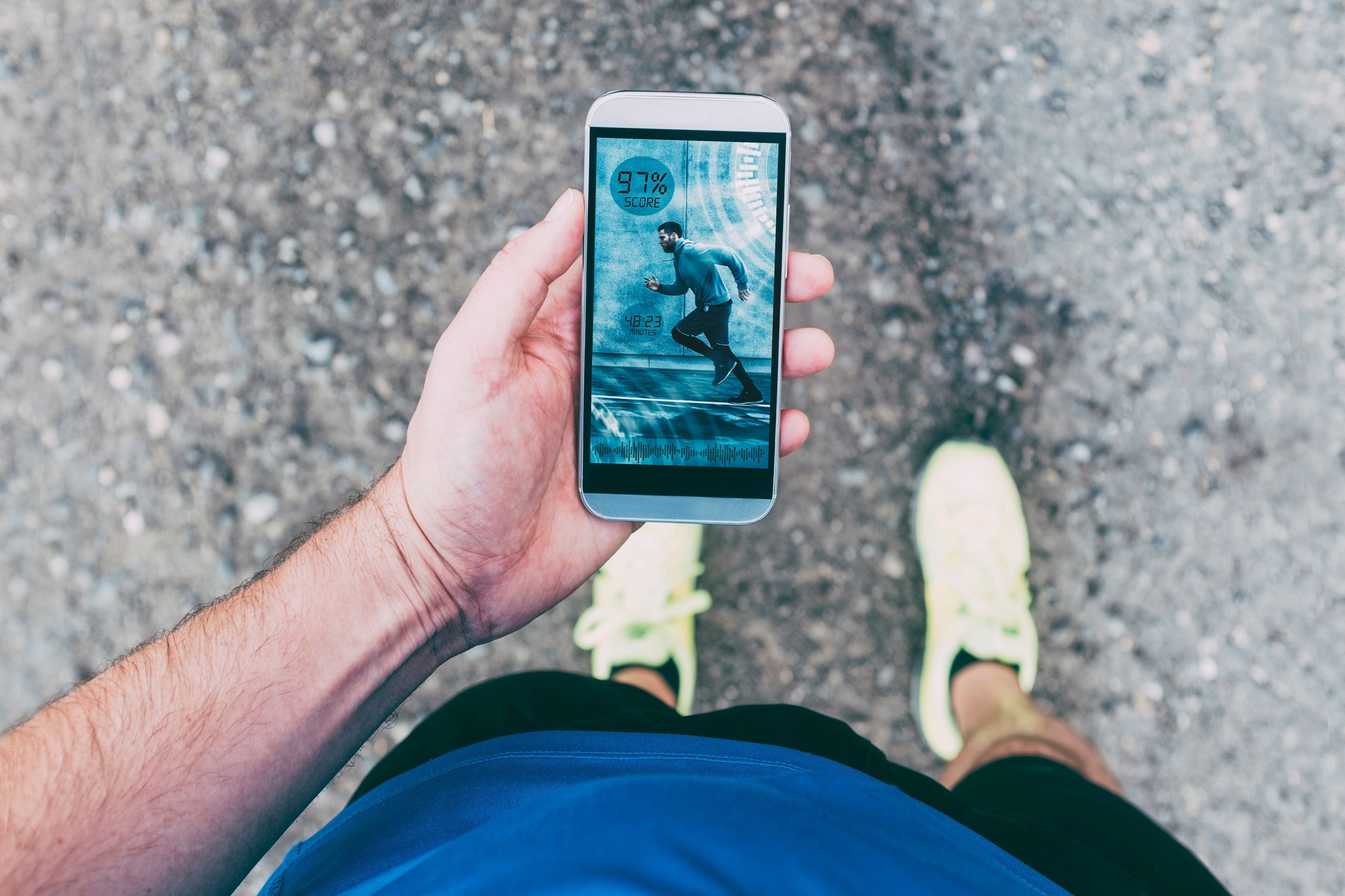 Runner holds smart phone with app during run