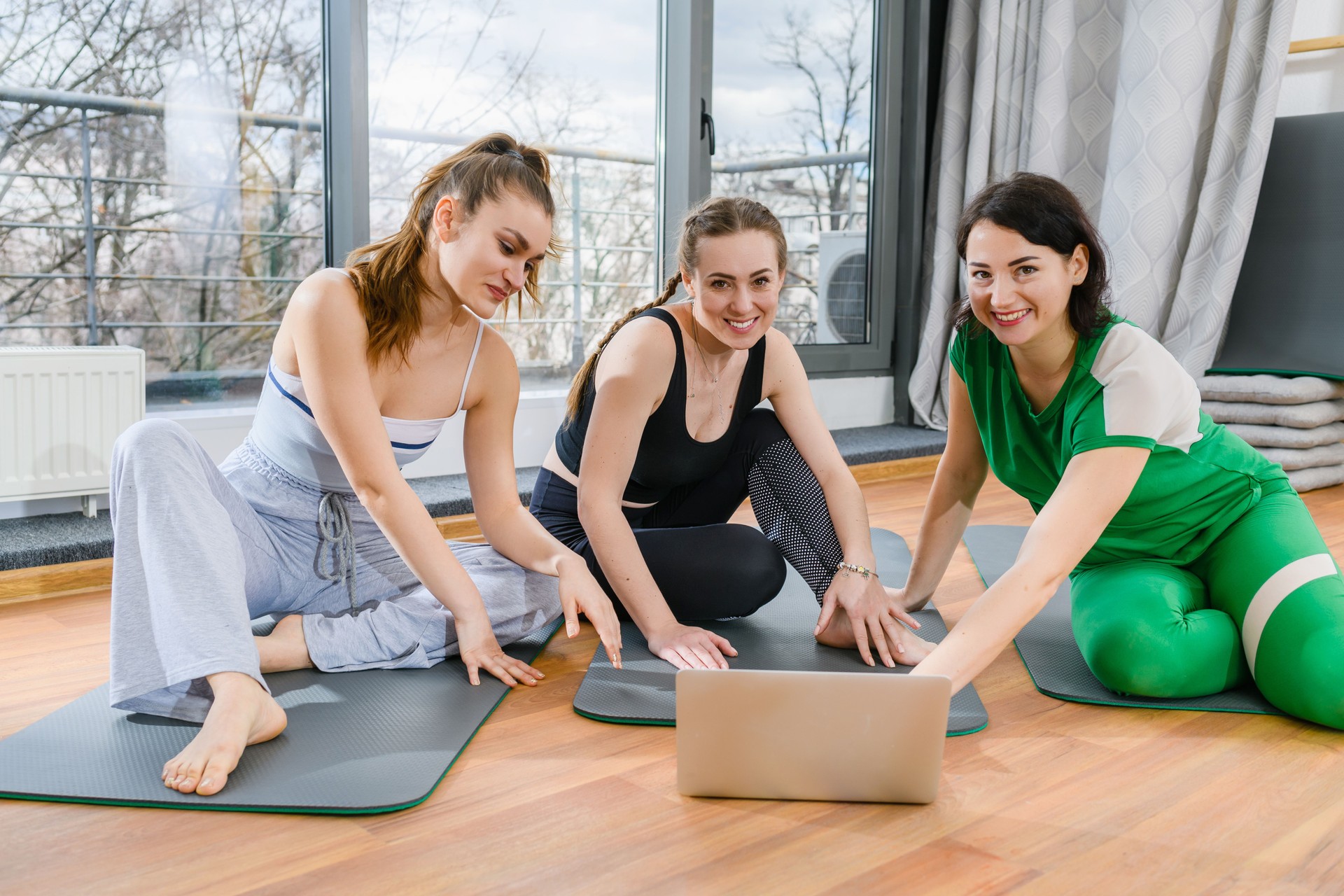 Girls in sportswear look at laptop screen